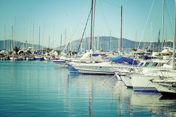 Boats in Alghero harbor on a clear day in vintage tone - Photo, Image