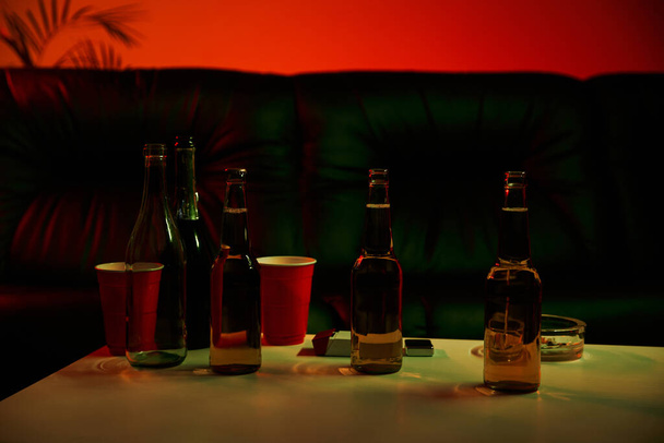 Una mesa está adornada con botellas de vino y copas - Foto, Imagen