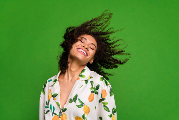Photo of pretty charming lady wear print shirt enjoying wind blowing empty space isolated green color background. - 写真・画像