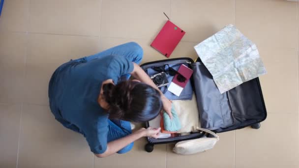 Топ-вид женских вещей в чемодане перед поездкой - Кадры, видео