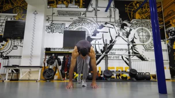 Young athlete doing push ups in handstand at modern gym. Muscular gymnast in sportswear doing hard stunts at fitness centre. Strong sporty man showing performance indoor. Healthy active lifestyle. - Footage, Video
