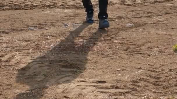 A man is stepping on a dirt field, and walking - Footage, Video