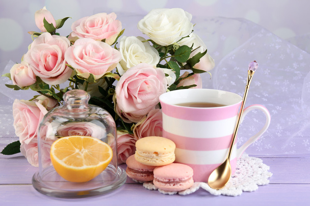 Colorful macaroons with cup of tea on wooden background - Foto, afbeelding