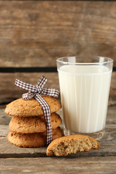 Tasty cookies and glass of milk on rustic wooden background - Valokuva, kuva