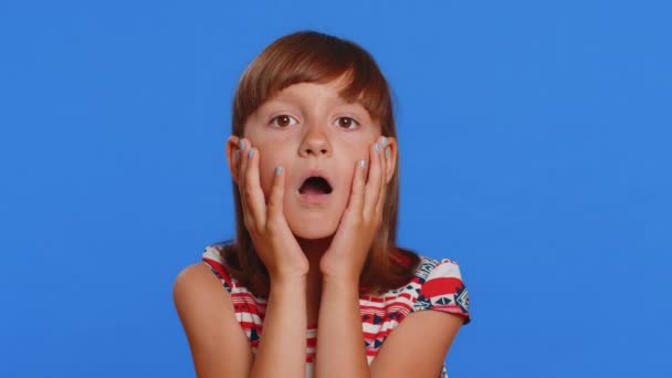 Oh my God, Wow. Young preteen child girl kid looking surprised at camera with big eyes, shocked by sudden victory game winning lottery goal achievemen good news. Children isolated on blue background - Footage, Video