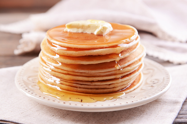 Delicious pancakes with honey on plate on table close-up - Fotoğraf, Görsel