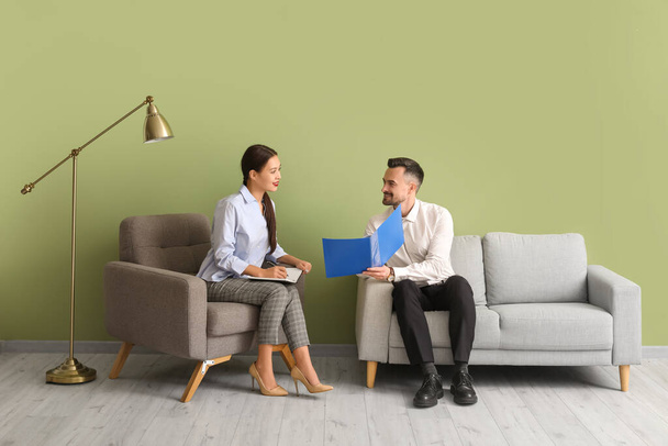 Human resources manager interviewing applicant near green wall in office - Photo, Image