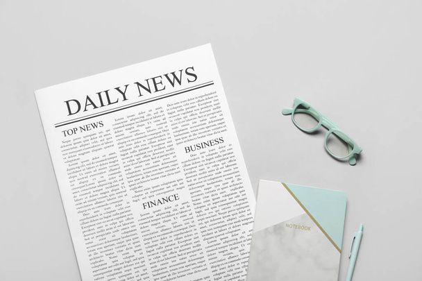 Newspaper with notebook, pen and eyeglasses on white background - Photo, Image