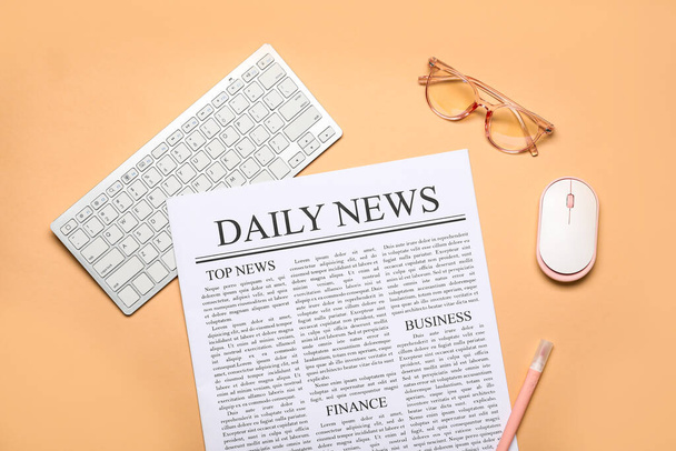 Newspaper with computer mouse, keyboard and eyeglasses on beige background - Photo, Image
