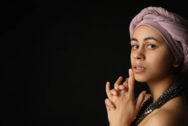 Modische junge Afroamerikanerin auf schwarzem Hintergrund - Foto, Bild