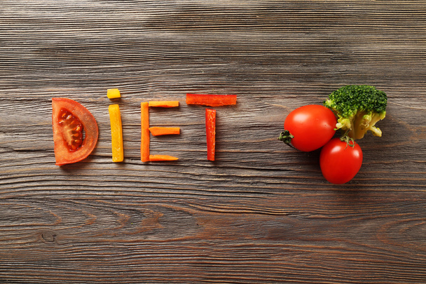 Word DIET made of sliced vegetables on wooden background - Fotoğraf, Görsel