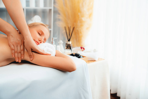 Кавказька жінка-клієнт насолоджується розслабляючим антистресовим спа-масажем і бродить з дозвіллям краси шкіри відпочинку в денному світлому навколишньому салоні спа в розкішному курорті або готелі. Тихіше - Фото, зображення