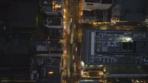 Birds ojo tiro de tráfico en la calle bordeada de edificios de varios pisos en el barrio urbano por la noche. Kioto, Japón. - Imágenes, Vídeo