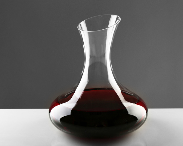 Glass carafe of wine on light background - Foto, afbeelding