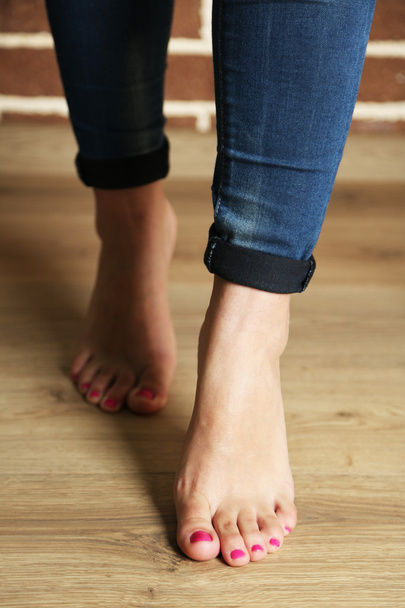 Beautiful female legs on wooden floor background - Фото, изображение