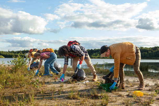 Старанна команда працює разом, щоб очистити берег озер, сприяючи збереженню навколишнього середовища. Групові зусилля в очищенні озер від еко-свідомих добровольців. Високоякісна фотографія - Фото, зображення