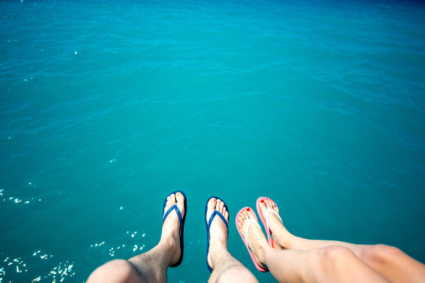 Páry nohy v bačkorách na pozadí moře - Fotografie, Obrázek
