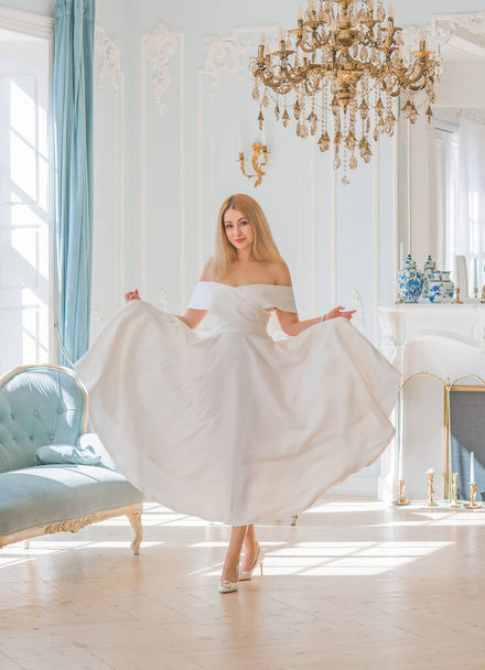 Romantikus régi pénzstílus. Nő viseljen fehér midi ruhát királyi világoskék háttér, divatos jelenet. Fogalom a vintage luxus életmód. - Fotó, kép