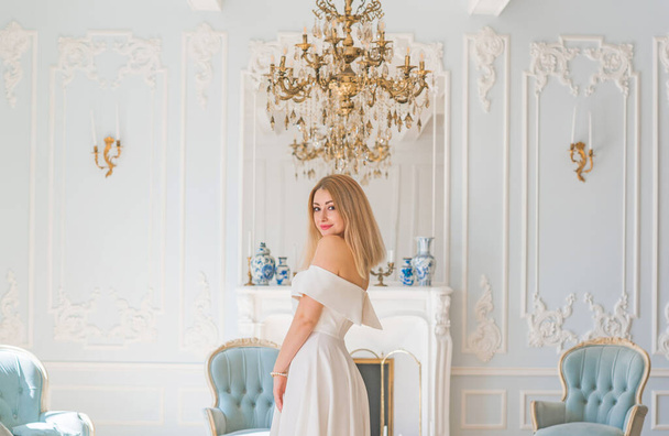 Ρομαντικό παλιό στυλ χρημάτων. Γυναίκα φορούν λευκό midi φόρεμα σε βασιλικό γαλάζιο φόντο, μοντέρνα σκηνή. Έννοια της vintage πολυτελή τρόπο ζωής. - Φωτογραφία, εικόνα