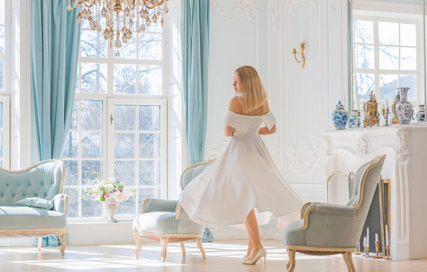 Romantic old money style. Woman wear white midi dress on royal light blue background, fashionable scene. Concept of vintage luxury lifestyle. - Photo, Image
