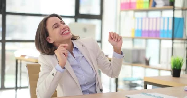 Energetic businesswoman dancing joyfully in a modern office. Businesswoman manager celebrating success at workplace - Footage, Video