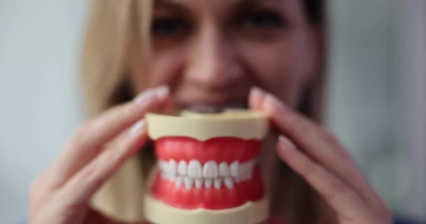 Primer plano de una mujer sonriendo con dentaduras postizas. Publicidad tratamiento dental e instalación de chapa - Imágenes, Vídeo