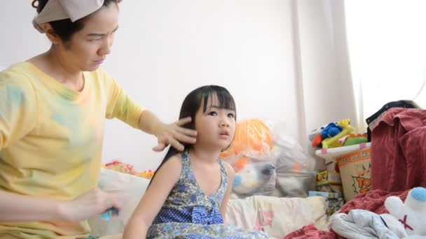 Asiática madre peinando su linda hija de pelo
. - Imágenes, Vídeo
