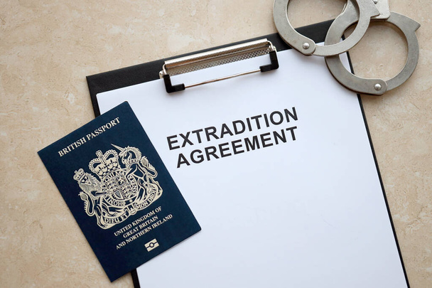 イギリスのパスポートとテーブルの上の手錠で伝統的な契約を閉じる - 写真・画像