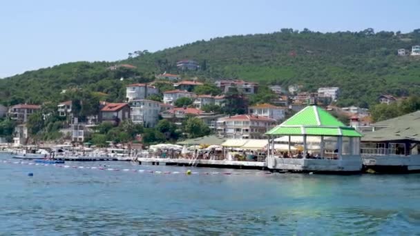 Istanbul, Turquie - 17 août 2023 : Côte de l'île des Princes avec des maisons insulaires traditionnelles et des gens à la plage - Séquence, vidéo