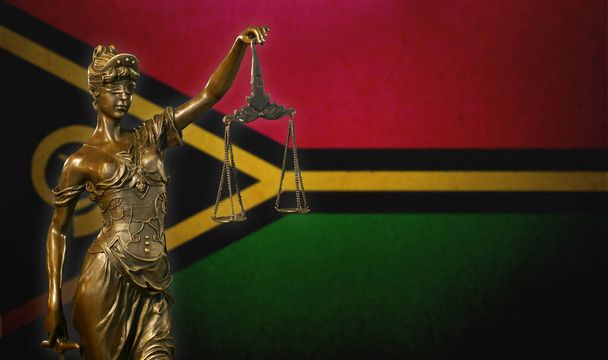Nahaufnahme einer kleinen Bronzestatuette der Lady Justice vor einer Flagge Vanuatus. - Foto, Bild