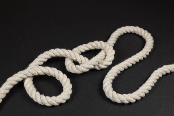 Rope with a knot on dark background. - Photo, Image