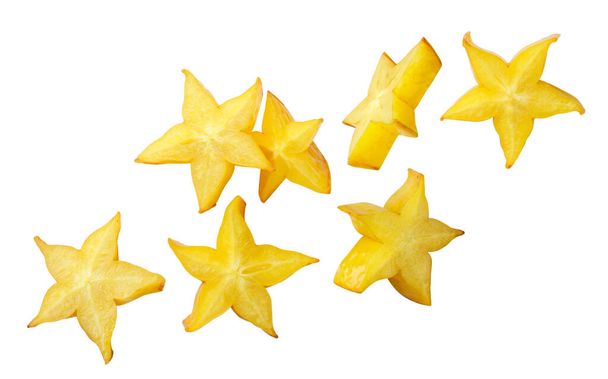 Stukken van ster carambola fruit vliegen close-up op een witte achtergrond. geïsoleerd - Foto, afbeelding