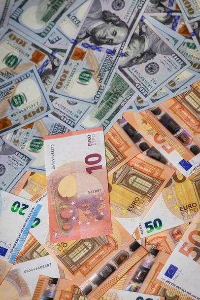 Closeup view of one hundred dollars banknote with euro money banknotes around as financial background.7 - Photo, Image