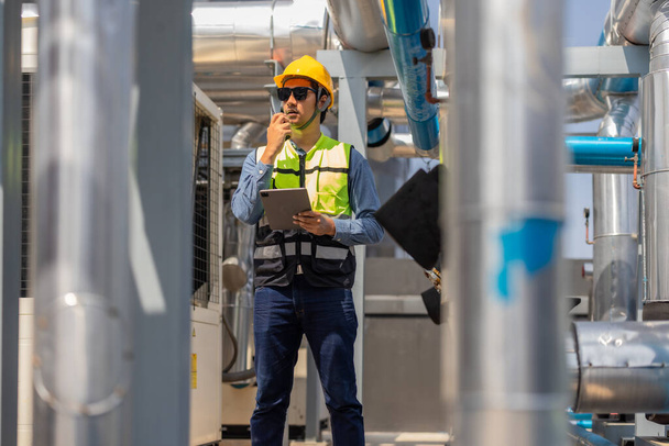 HVAC technician use tablet to record data and conduct real-time analysis. Using specialized software to diagnose and optimize mechanical, electrical, and plumbing systems with energy efficiency plan - Foto, Imagem
