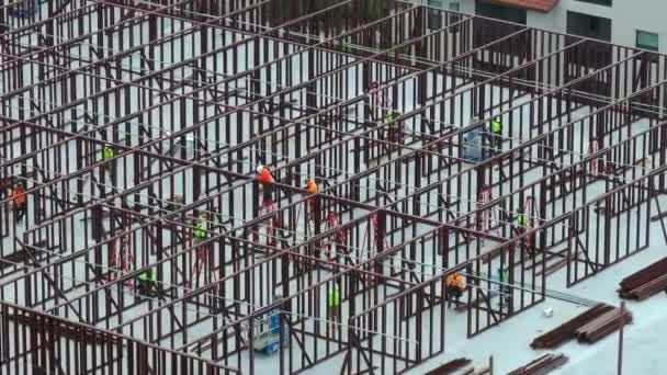 Bouwplaats met hardhat werknemers monteren metalen frame muren. Luchtfoto van een groot ontwikkelingsgebied van commerciële structuur. Vastgoedmarkt in de VS - Video