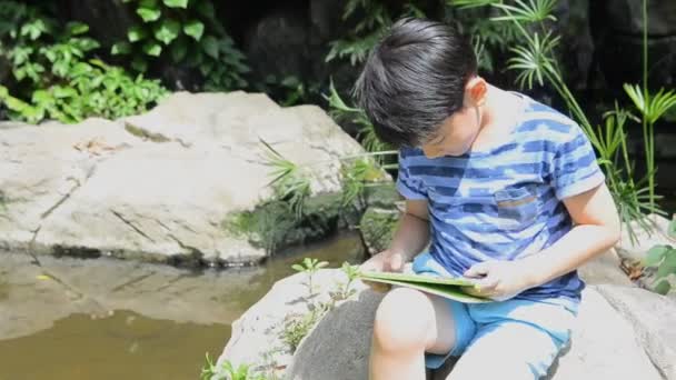 Malé Asijské dítě používající digitální tablet . - Záběry, video