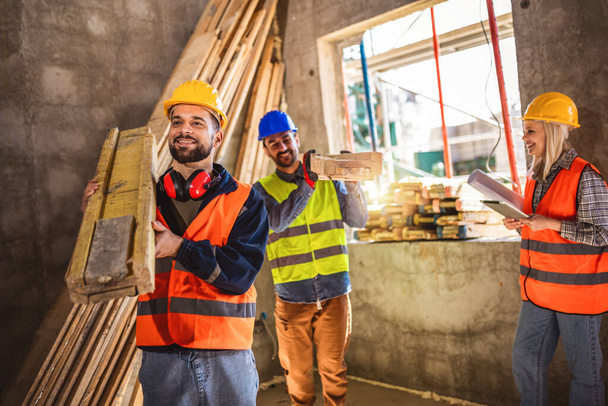 Deux ouvriers de la construction portant un échafaudage à une échafaudage de bâtiment - concepts de personnes au travail - Photo, image
