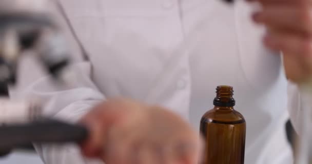 Επιστήμονας χημικός ρίχνει καθαρό υγρό από μπουκάλι στο χέρι σε εργαστήριο closeup 4k ταινία αργή κίνηση. Κανόνες ασφαλείας στην έννοια του χημικού εργαστηρίου - Πλάνα, βίντεο