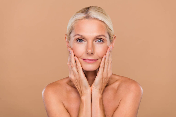 Photo of adorable pretty woman naked hands arms cheeks cheekbones using face cream isolated beige color background. - Fotografie, Obrázek