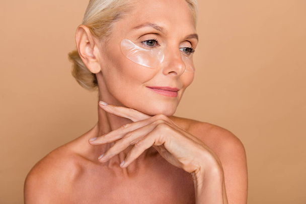Photo portrait of attractive older woman touching salon spa procedures aesthetic pretty ideal shoulders off isolated on beige color background. - Фото, зображення