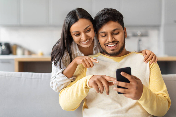 Індійський чоловік і жінка зосереджені на екрані мобільного телефону, можливо, обговорюючи зміст або обмінюючись інформацією. - Фото, зображення
