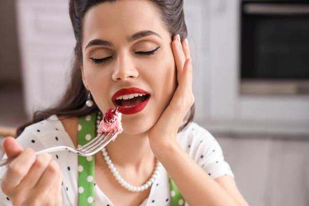 Portret pięknej kobiety jedzącej babeczki w kuchni, zbliżenie - Zdjęcie, obraz