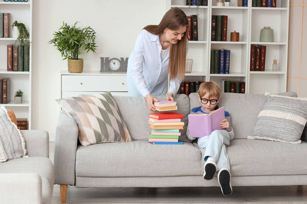 Evde farklı kitapları olan sevimli bir çocuk ve annesi. - Fotoğraf, Görsel