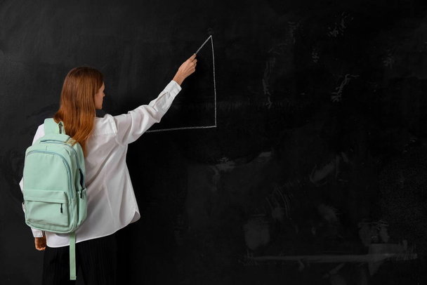 Female student drawing triangle on blackboard. End of school concept - Photo, Image