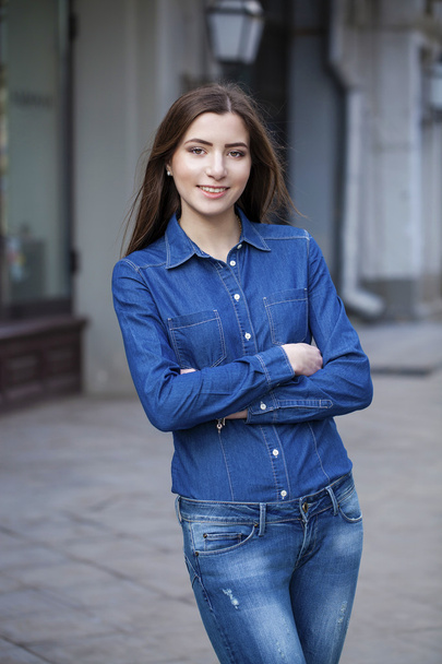Portrait of a beautiful young woman in a blue jeans shirt on the - Valokuva, kuva