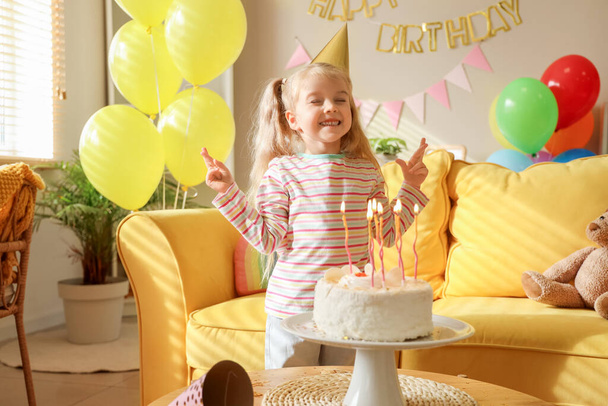 Söpö pieni tyttö puolue hattu kakku, ilmapalloja ja koristeet syntymäpäivä kotona - Valokuva, kuva