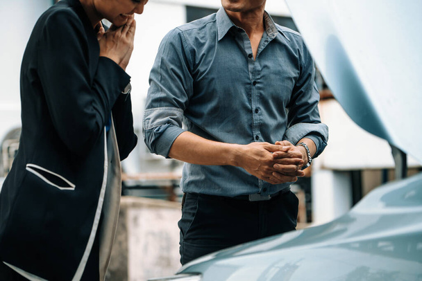Erkek kadına araba sorununu çözmesi için yardım eder. Hasarlı parçayı tamir etmek için arabanın kaputunu açtı. uds - Fotoğraf, Görsel
