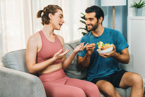 Healthy sporty and vegetarian couple in sportswear with a bowl of fruit and vegetable. Healthy cuisine nutrition and vegan lifestyle for fitness body physique at gaiety home concept. - Photo, Image
