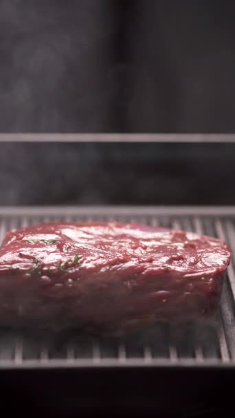Szef kuchni grilluje polędwicę wołową na grillu parowym. Letnia i grillowana koncepcja mięsa. Pionowe wideo - Materiał filmowy, wideo