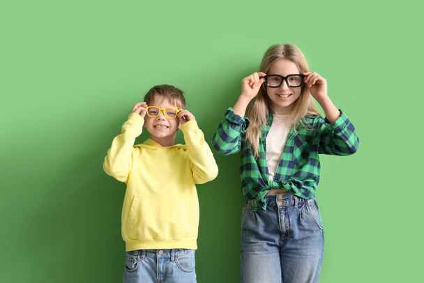 Söpöt pienet lapset silmälaseissa vihreällä taustalla - Valokuva, kuva